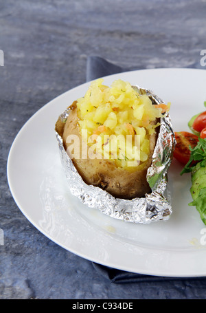 Baked potato filled with sour cream and  cheese, with salad Stock Photo