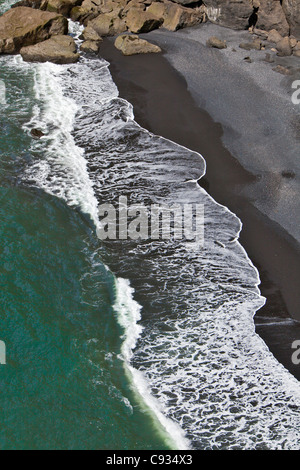 The black basalt sand beach at Dyrholaey pounded by waves from the North Atlantic Ocean. Stock Photo