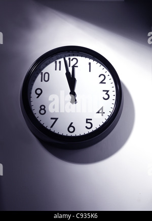 Wall clock set to just before 12 Stock Photo