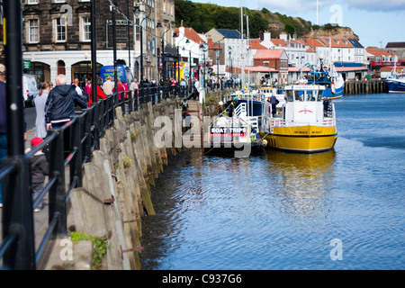 Whitby by the sea, with the boats at the docks and dockyard showing the beautiful scenic views with the boats in the distance. Stock Photo