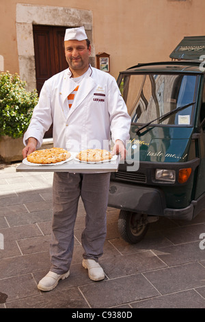 Italy, Marches Region, Visso. The local baker with his pastries and his classic Ape 50 delivery van. Stock Photo