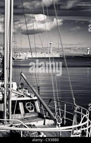 Whitby by the sea, with the boats at the docks and dockyard showing the beautiful  views with the lighthouse in the distance. Stock Photo