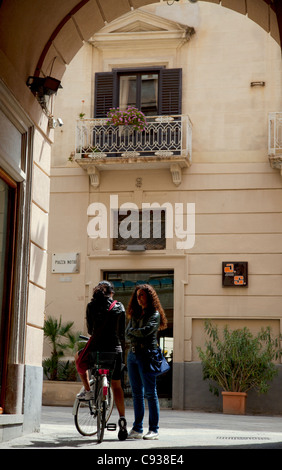 Sicily, Italy, Western Europe; Two young women talking in the old town centre of Trapani Stock Photo