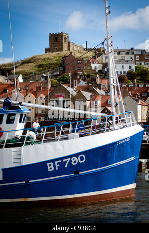 Whitby by the sea, with the boats at the docks and dockyard showing the beautiful scenic views with the abbey in the distance. Stock Photo