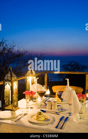 Malawi, Lake Malawi National Park.  Dinner laid on the veranda of one of the chalets at Pumulani Lodge with Lake Malawi behind. Stock Photo