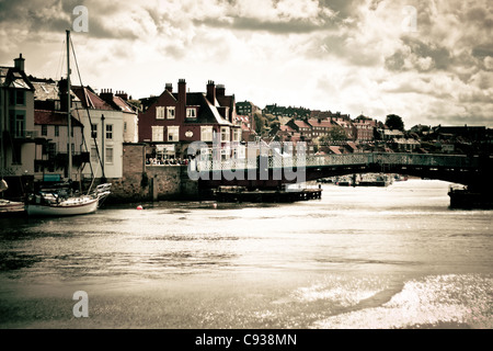 Whitby by the sea, with the boats at the docks and dockyard showing the beautiful scenic views with the bridge in the distance. Stock Photo