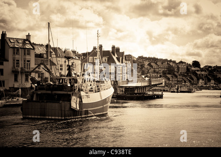 Whitby by the sea, with the boats at the docks and dockyard showing the beautiful scenic views with the bridge in the distance. Stock Photo