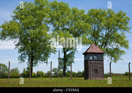 Poland, Brzezinka, Auschwitz II - Birkenau. A wooden watchtower near the barbed wire perimeter fence. Stock Photo