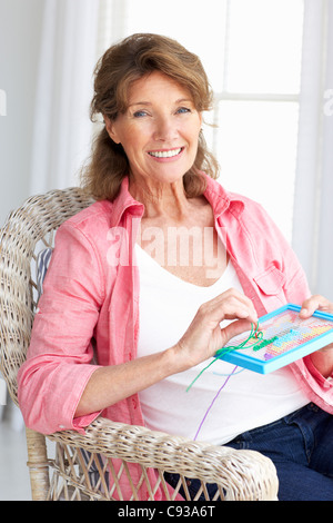 Senior woman doing cross stitch Stock Photo