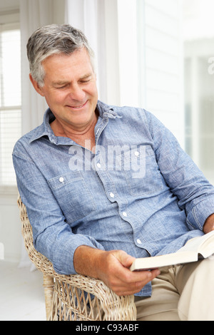 Senior man relaxing at home with a book Stock Photo