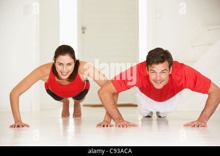 Couple doing push-ups in home gym Stock Photo