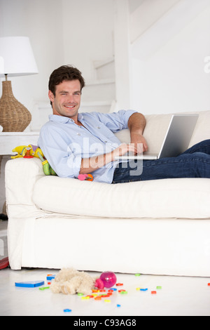 Busy father working on laptop Stock Photo