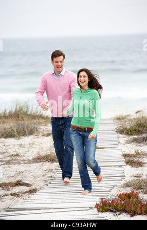 Couple running along beach path