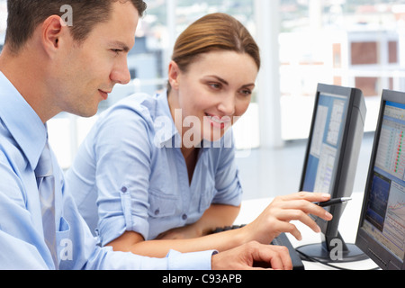 Businessman and woman working on computers Stock Photo