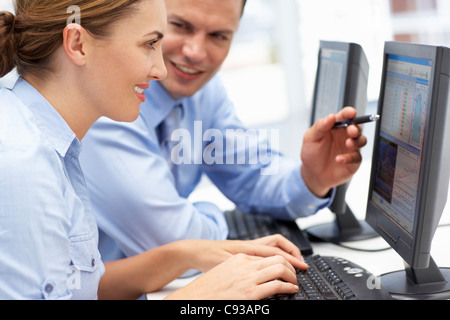 Business man and woman working on computers Stock Photo
