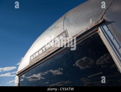 Rear section of a silver Airstream caravan with blue sky and clouds reflected in the rear window, Seligman, Arizona, USA Stock Photo