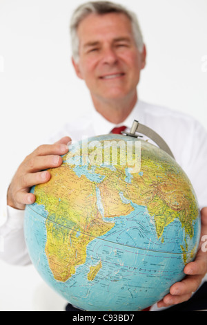 Senior businessman holding globe Stock Photo