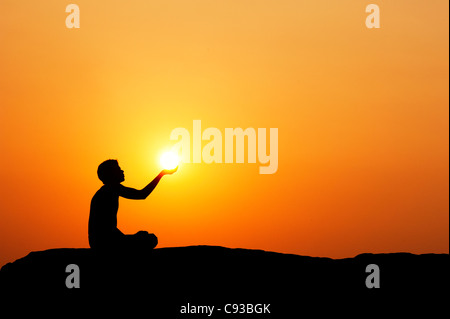 Indian man holding the sun. Silhouette. India