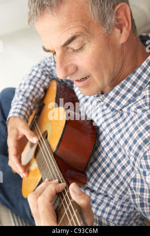 Mid age man playing acoustic guitar Stock Photo