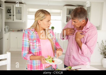 Father making teenage daughter do chores at home Stock Photo