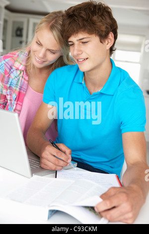 Teenage boy and girl doing homework with laptop Stock Photo
