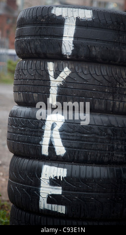 A sign stating the obvious on a pile of used tyres. Stock Photo