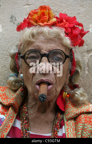 Eccentric elderly Cuban woman Graciela Gonzalez also known as Granny Puretta smokes cigar at age 84 in the historical centre in Havana, Cuba. Stock Photo
