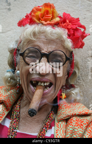 Eccentric elderly Cuban woman Graciela Gonzalez also known as Granny Puretta smokes cigar at age 84 in the historical centre in Havana, Cuba. Stock Photo