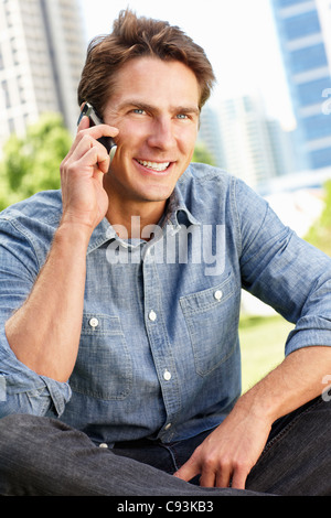 Man in city park talking on phone Stock Photo
