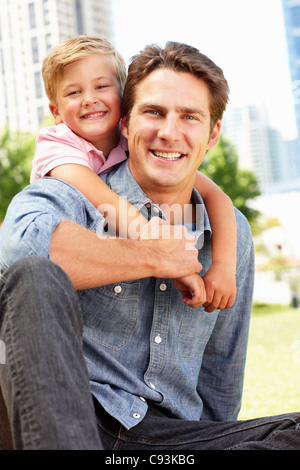 Man sitting in city park with young son Stock Photo