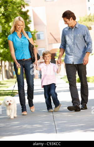 Family walking with dog in city street Stock Photo