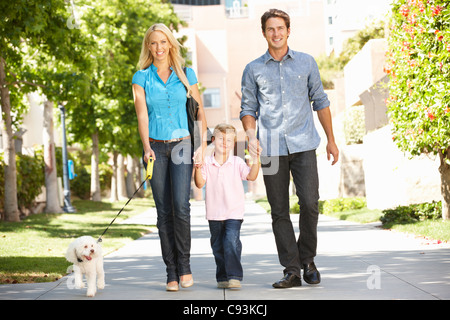 Family walking with dog in city street Stock Photo