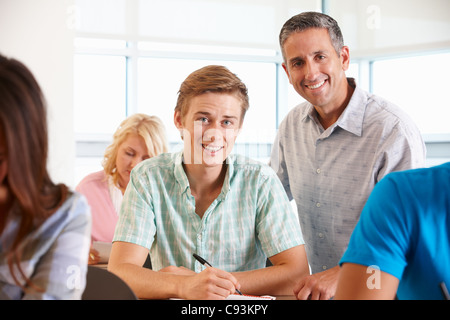Tutor helping student in class Stock Photo