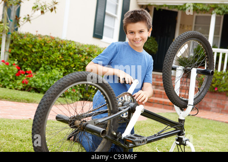 boy fixing bike in garden Stock Photo