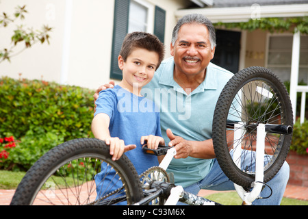 boy and grandfather fixing bike Stock Photo