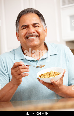 Senior man eating cereal Stock Photo