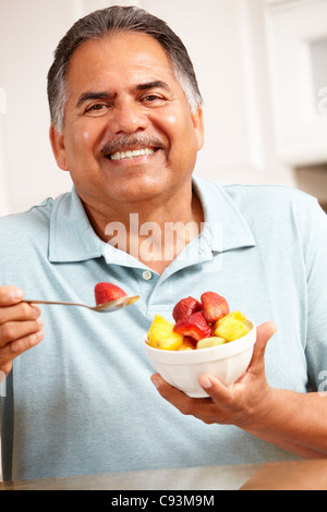 Senior man eating fruit Stock Photo