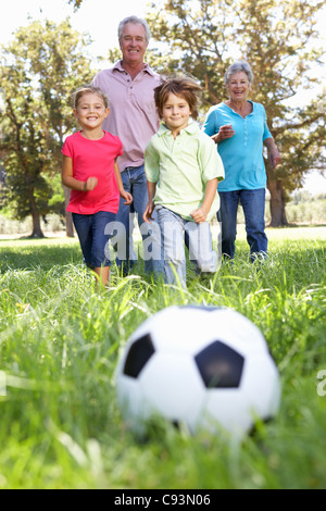 Grandparents playing football with grandchilderen Stock Photo