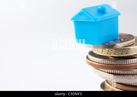 Small model house and coins Stock Photo