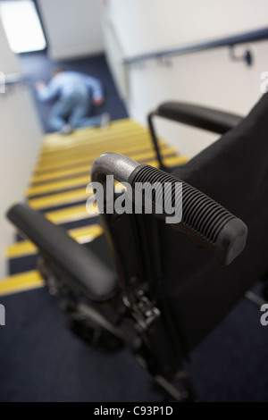 Man in wheelchair falling downstairs Stock Photo