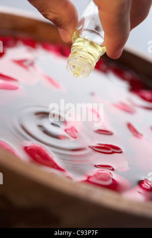 Man pouring essential oil into water Stock Photo