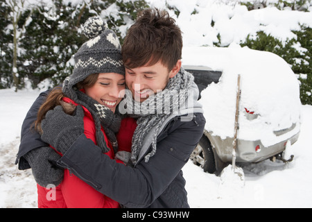 Young couple in snow with car Stock Photo