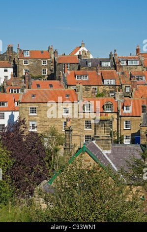 Looking across rooftops of houses homes cottages in summer Robin Hoods Bay North Yorkshire England UK United Kingdom GB Great Britain Stock Photo