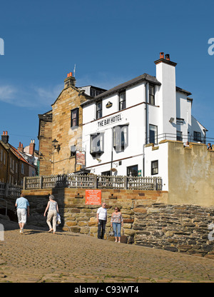People tourists visitors beside The Bay Hotel in summer Robin Hoods Bay North Yorkshire England UK United Kingdom GB Great Britain Stock Photo