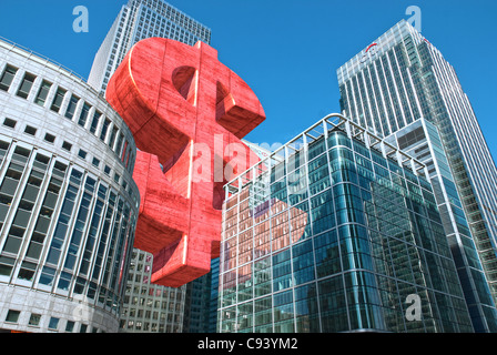 Digitally altered Photograph by hitandrun media. A Giant Dollar symbol, floating between buildings in Canary Wharf, London. Stock Photo