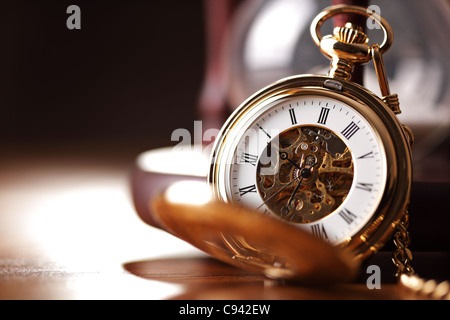 Gold pocket watch and hourglass Stock Photo