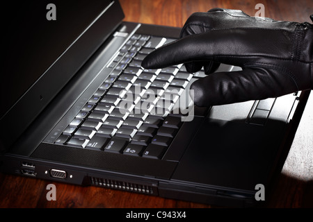Man stealing data from a laptop Stock Photo