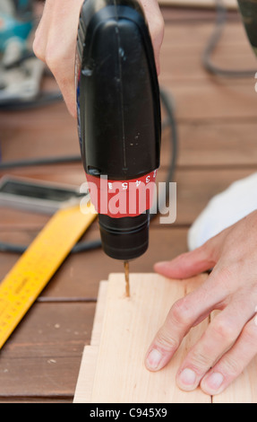 A carpenter using an electric drill. Stock Photo