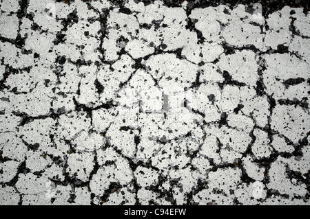 Closeup of broken and cracked painted traffic line on blacktop Stock Photo