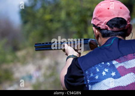 Clay pigeon shooting. Close up of a man with a shotgun and taking aim at a clay pigeon shoot Stock Photo